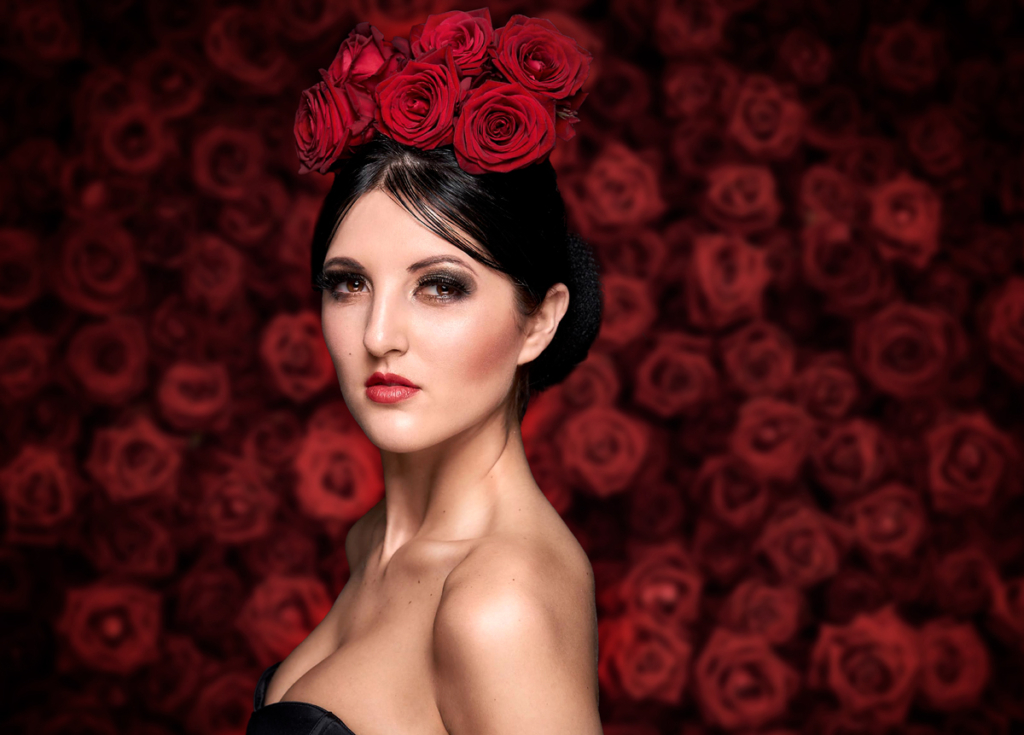 Portrait einer Frau mit Rosen auf dem Kopf, stehend vor einer Wand aus Rosen. Professionelles Portraitfoto von Roman Hammer - hammerfoto.at | Portraitfotograf Wien